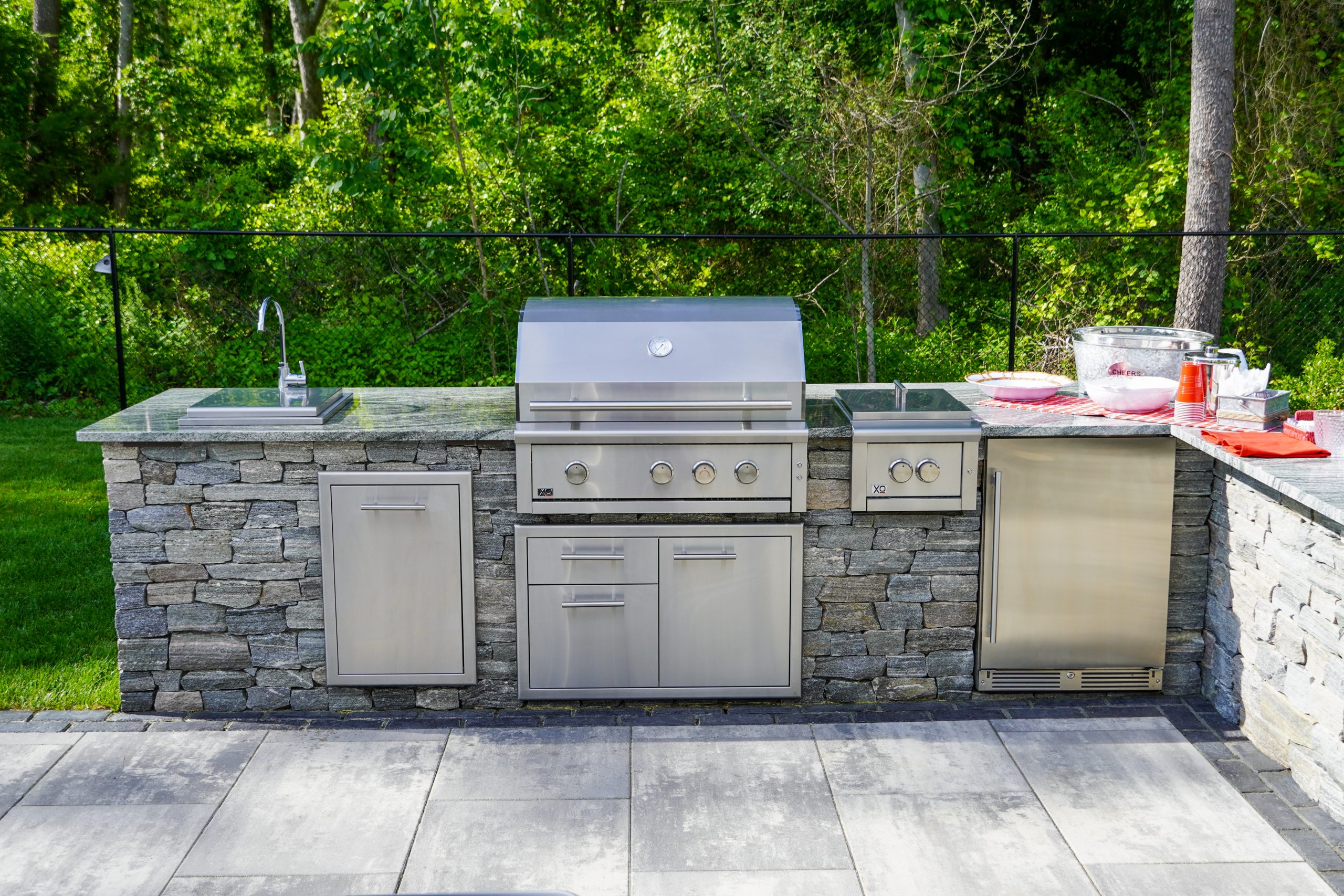 Completed outdoor kitchen with built-in grill and stone facing