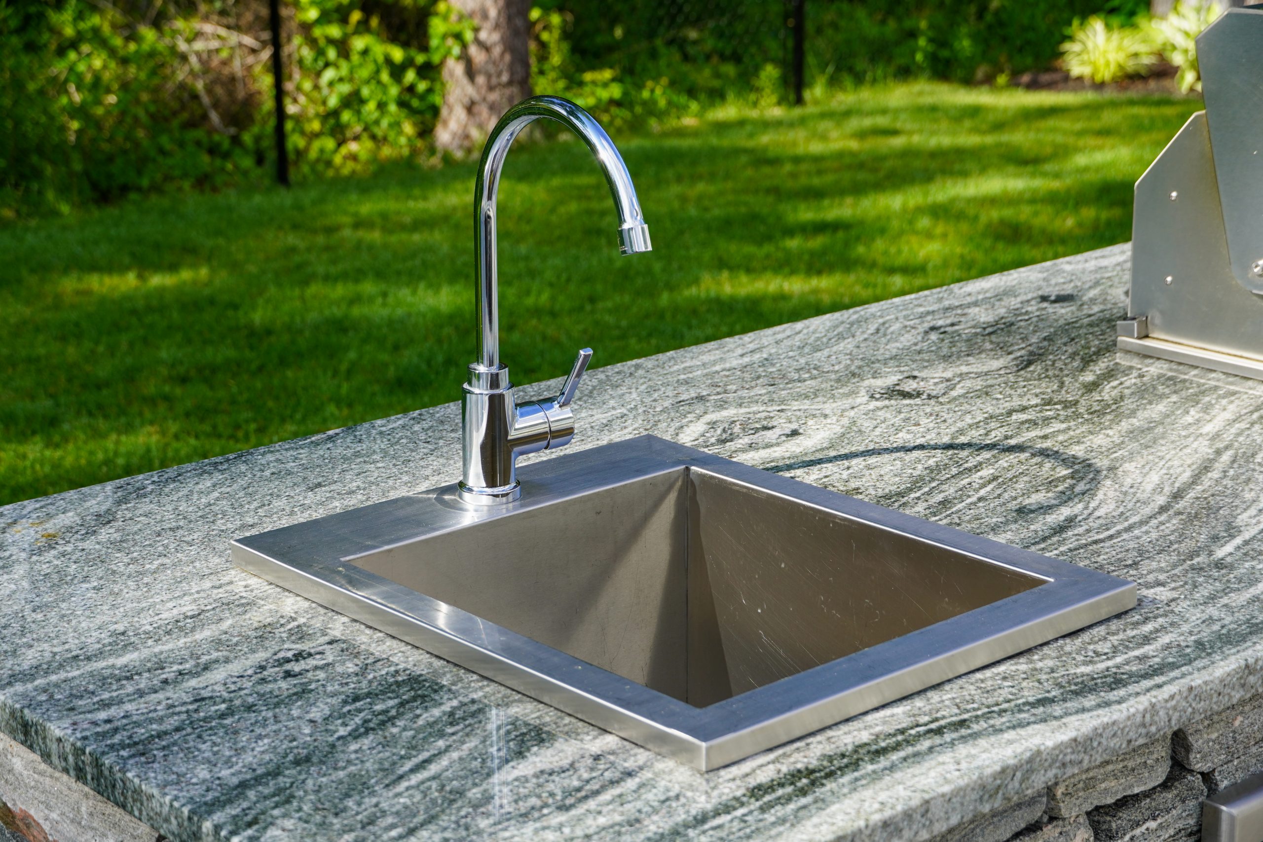 Outdoor kitchen with granite countertop and built-in grill station